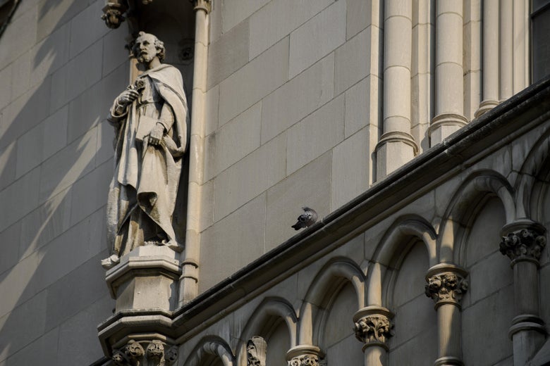 A shot of the side of St. Paul Cathedral, with a sculpture of a figure praying.
